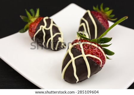 red chocolate dipped in dark chocolate decorated with white chocolate drizzle