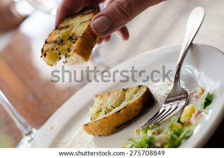 Holding garlic bread between two fingers