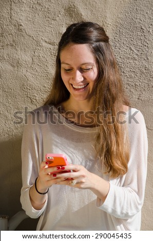 Young female looking at her cell phone, reading a text message