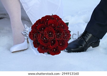 Wedding bouquet of roses and couple\'s feet.