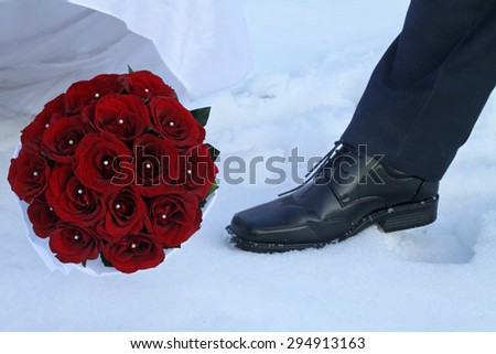 Wedding bouquet of roses and groom foot.