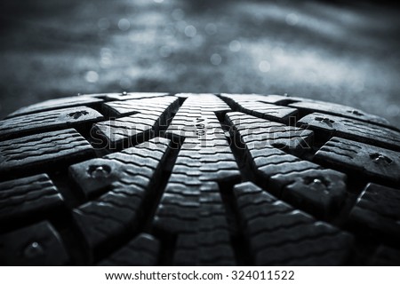 Winter tires photographed in close-up view in Finland. Focus point is in the center of the image numbers. The front and back of the image out of focus. Image includes a heavy effect.