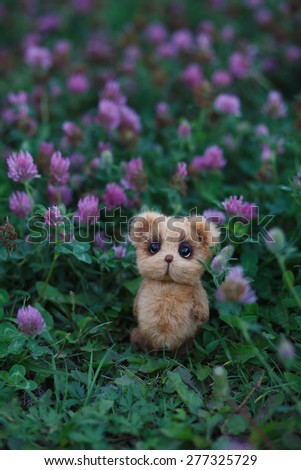 Brown artist Teddy bear in violet flower garden