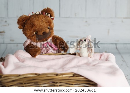 Brown artist teddy bear in pink clothes on white background