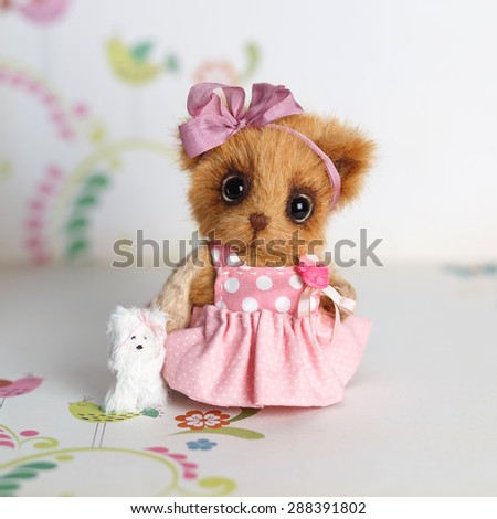 Brown artist Teddy bear in pink clothes with white dog