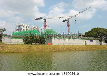 Singapore, Singapore - Feb 25 : Construction with tower cranes for public housing along river bank in the day on Feb 25, 2014