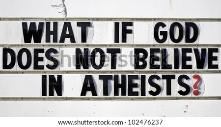 A roadside sign stating What If God Does Not Believe In Atheists?