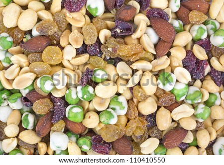 A very close view of trail mix with wasabi peas, cranberries almonds and golden raisins.