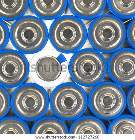 A close view of several AA size batteries with one negative side up and the remainder positive side up.