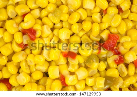 A very close view of cut corn with red and green peppers.