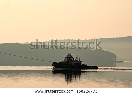 A single tugboat on the Penobscot river in the early morning light.