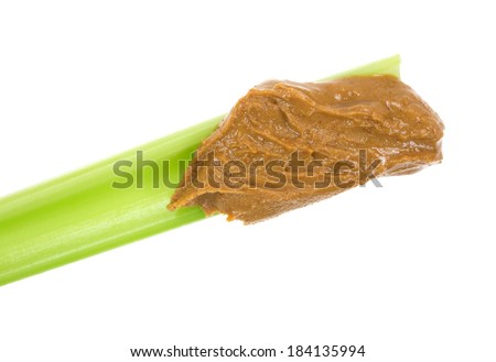 Close view of a fresh celery stalk with natural peanut butter on a white background.