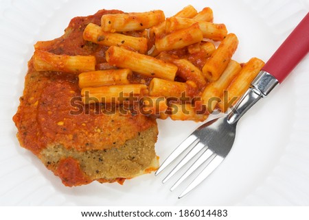 Close view of a TV dinner of breaded chicken with pasta in a tomato sauce on a paper plate with fork.