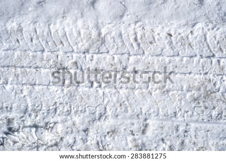 A close view of tire tracks in hard packed snow.