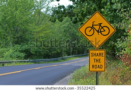 Bicycle road sign next to a rural highway.