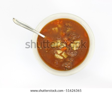 Single serving of beef pot roast stew in an old bowl with a silver spoon