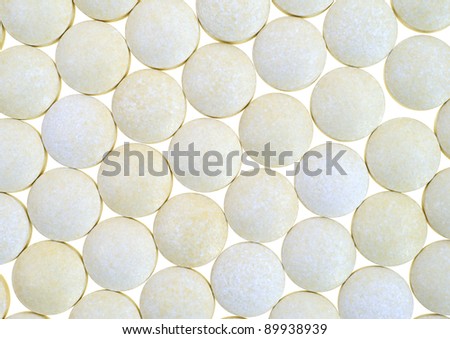 A very close view of several iron tablets in rows against a white background.