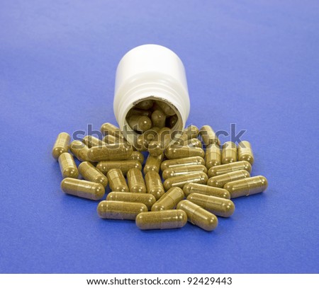 A white bottle with echinacea immune health supplement capsules spilling onto a blue background.