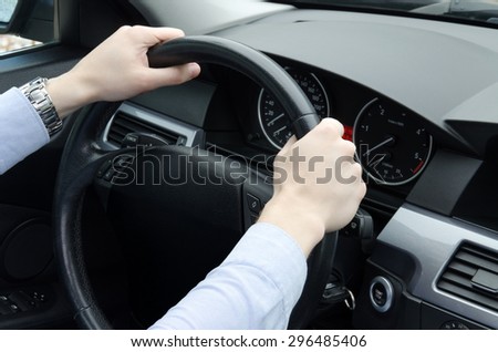 Men's hands holding the steering wheel