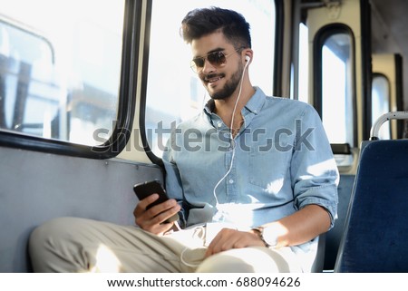 Man in the bus listens to music.