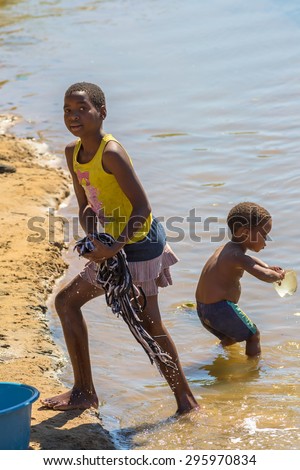 UMkhuze Game Reserve, South Africa - August 24, 2014: African children washing their clothes to the river on the road leading to UMkhuze