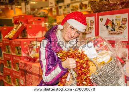 Bologna, Italy - December 13, 2014: Woman showing typical italian nationwide food products in for sale only during Christmas weeks: marmelade, mustard, cold cuts, almond paste, pickles, italian wine.