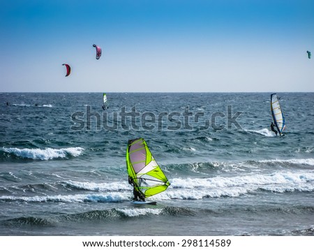 Tenerife, Canary Islands, Spain - December 22, 2008: A group of guys make kitesuifing and windsurf on waves of the Atlantic, at El Medano beach