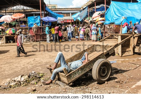 Arusha, Tanzania, Africa - January 2, 2013: Man lying on a wooden cart sleeps in a market of the town