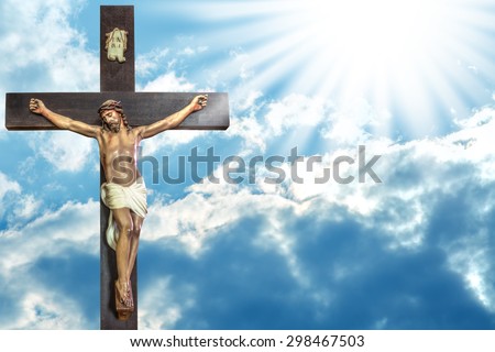 Jesus Christ to paradise: cross of Jesus Christ on sky background with a shining celestial light from above.