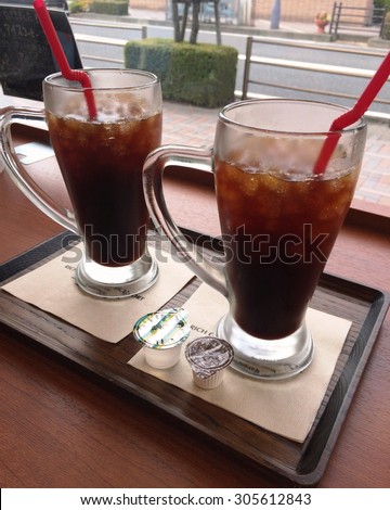 two ice black coffees on a woody table