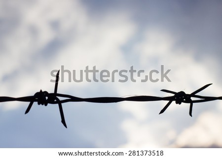 Silhouette of barbed Wire on white cloud background