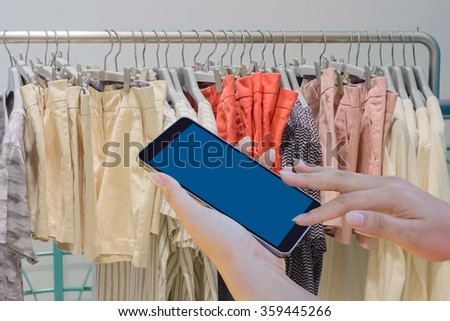 woman hand using mobile phone at Clothing Store