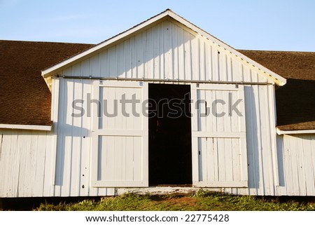 Partly open white barn doors.