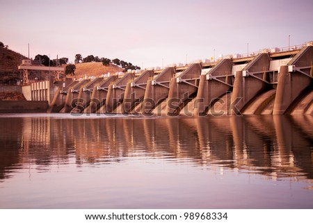 A low-head dam used for water supply and flood control with numerous spillway gates on the American River.