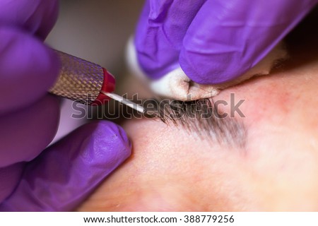Cosmetologist applying permanent makeup on eyebrows\
Selective focus and shallow Depth of field