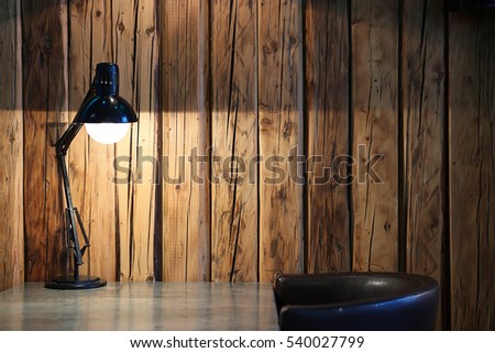 Vintage black desk lamp on wood background\Vintage background with lighting retro desk lamp on wood background