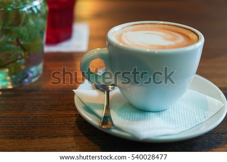 Coffee cup of cappuccino. A cup of cappuccino on the table at the bar.