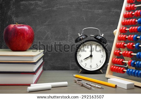 Back To School / School Supplies, an Apple and an Alarm Clock on a Desk in front of a Blackboard