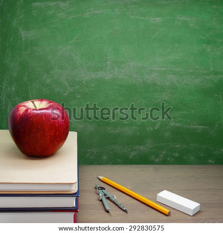Back To School - A Red Apple on a Pile of Books in front of a Chalkboard