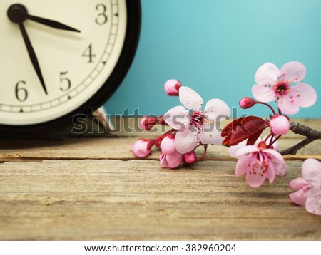 Spring Time Change / Pink Blossoms and an Alarm Clock on an Old Wooden Table