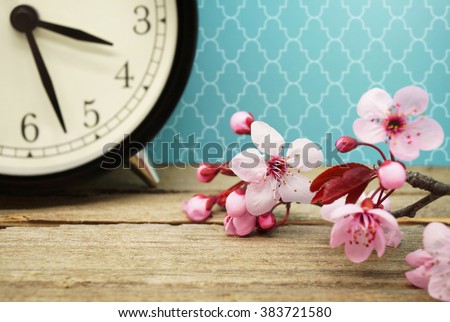 Spring Time / Pink Blossoms and an Alarm Clock on an Old Wooden Table