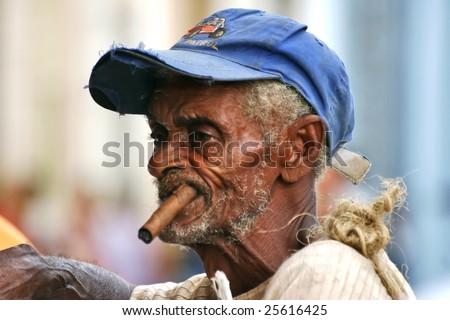 CUBA - OCTOBER 25: Picturesque Cuban old man is on one of the streets of Trinidad on October 25, 2005 in Cuba. Cuba is famous of its cigars.