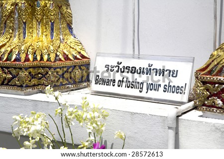 Sign outside buddhist temple in Bangkok, Thailand (etiquette demands removal of shoes at buddhist temples)