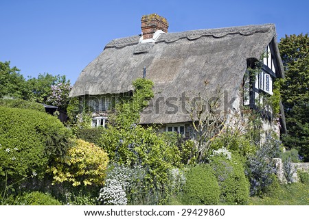 A pretty thatched cottage in a rural village in Great Britain, in spring