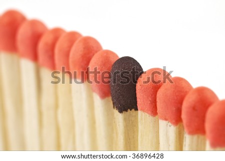 Macro shot of pink matches and one brown match with a shallow depth of field to focus on the brown match.