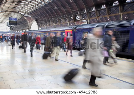 Commuters at Paddington station blurred with slow shutter speed, with all logos removed and all faces blurred beyond recognition.