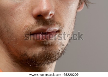 Unshaved man  part of face on grey