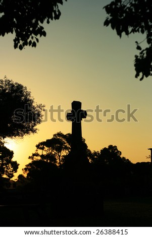 Silhouette of a Cross at sunset in a church graveyard