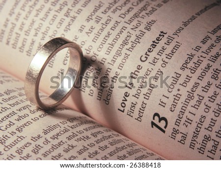 stock photo Wedding ring with heart shaped shadow on a bible open to a