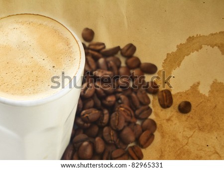 Cup of Coffee with Beans and a Stained Textured Background